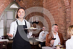 Nice female waiter showing country restaurant