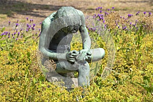 A nice figurine of a child picking a splinter out of his foot in a park in Alphen aan den Rijn, the Netherlands