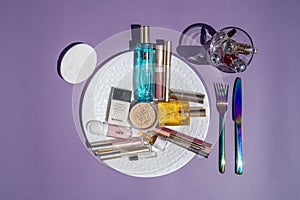 Nice, FRANCE - 21.05.2021 Aesthetic photo. Cosmetic makeup set on the plate on the table as lunch. Powder, lipstick