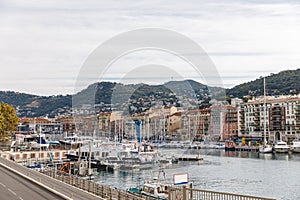 NICE, FRANCE - 17 SEPTEMBER 2017: harbour of old european city located on seashore with hills on background