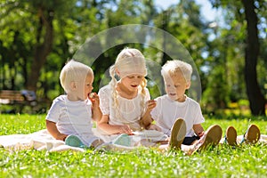 Nice girl and boys sitting in the park all together