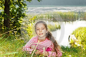 Nice girl dreaming near the river at sunset