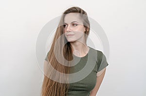 Nice girl with long hair looks thoughtfully to the left