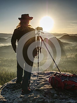 Nice girl photographer in cowboy cap photographing on  camera