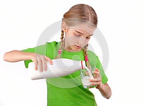 Nice girl pours milk from a bottle into glass photo