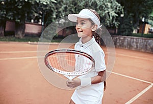 Nice girl with racket in hands playing game of tennis