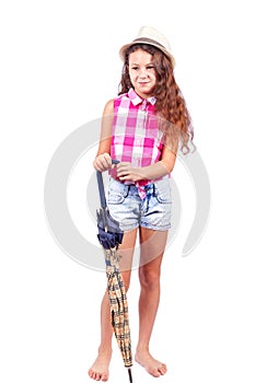 A nice girl in a shirt and shorts in a hat with an umbrella