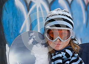 Nice girl with snowboard, graffiti background.