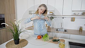 Charming woman cooks phone in hands and composes composition of