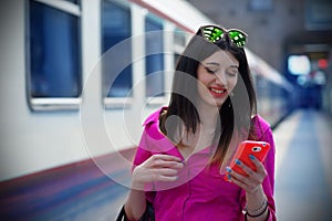 Nice Girl at the Train Station with her Smartphone photo