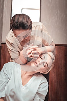 Nice good looking woman having a neck massage