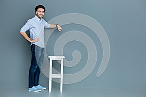 Nice handsome man standing near the stool