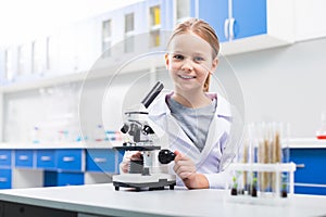 Nice happy girl using microscope