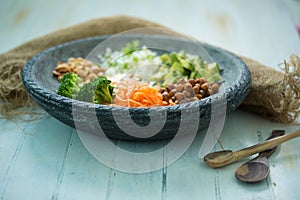 Nice image of a fresh salad on a wooden table with wooden spoons.