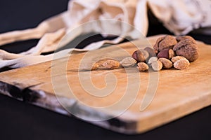 A nice image of mixed nuts and grapes on a wooden surface.
