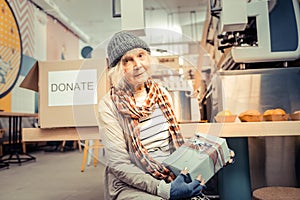 Nice joyful homeless woman receiving a gift