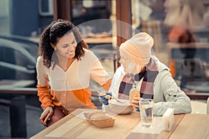 Nice joyful woman helping poor homeless people