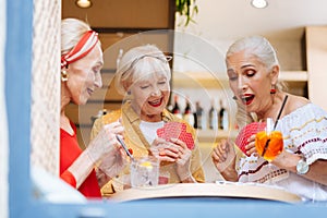 Nice joyful woman looking at their cards