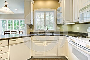 Nice kitchen with white cabinets and black countertops.