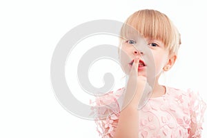 Nice little girl holding finger in front of mouth