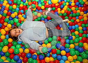 Nice little girl play dipped in colored balls of kindergarten po