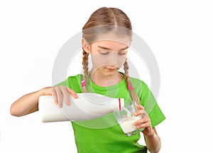 Nice little girl pours milk from a bottle into glass photo