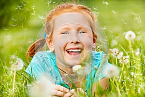 Nice little girl smiles laying on a grass