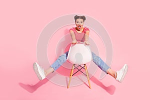 Nice-looking attractive glamorous lovely shine crazy girl wearing striped tshirt jeans sitting on chair having fun