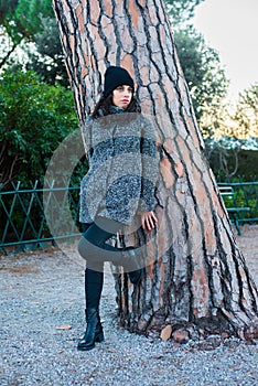 Nice looking girl posing next to a tree in the park