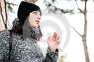 Nice looking girl smoking a sigarette in a park