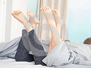 Nice loving couple lying in bed under blanket.