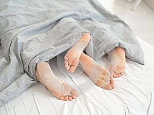 Nice loving couple lying in bed under blanket.