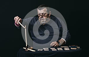 Portrait of senior man in mask - soothsayer  lighting candle while doing cartomancy photo