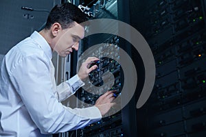 Nice male engineer checking the network server