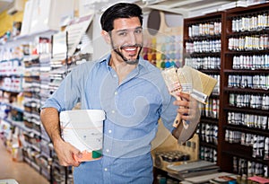 Nice man choosing brushes and varnishes