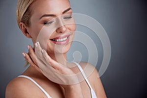 Nice middle aged woman applying face cream