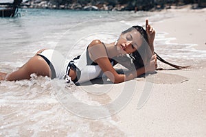 Nice model female in bathing suit l sunbathes on deserted beach.