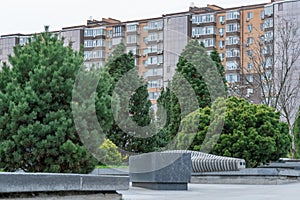 Nice modern leisure city park with benchs surrounded high-rise building.