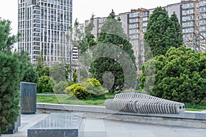 Nice modern leisure city park with benchs surrounded high-rise building.