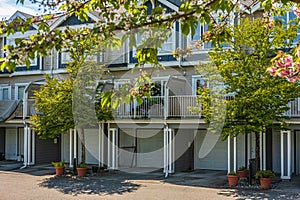 Nice neighborhood on a sunny day. Row of garage doors at parking area for townhouses.Garage door with short driveway