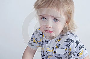 Nice offended kid with insulted expression face, purses his lips in discontent concept of children`s emotions