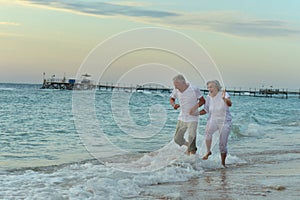 Nice old couple running on sea beach