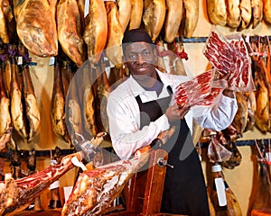 Nice owner of butcher shop selling jamon