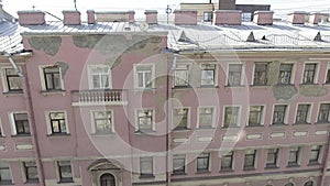 Nice panoramic view of pink house facade with windows, rooftops, gutter pipes.
