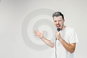 Nice picture of an emotional guy singing in microphone. His trying to do his best and reaches the highest note in the