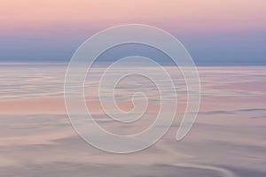 Nice pink sunset seascape in pastel shades, peace and calm outdoor travel background, motion blur