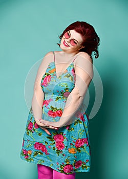 Nice plus-size lady overweight fat woman in sunglasses and colorful clothes act like a little girl, shy, is touched by cuties