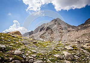 Nice postcard of a mountain surrounded by green meadows with rocks in summer