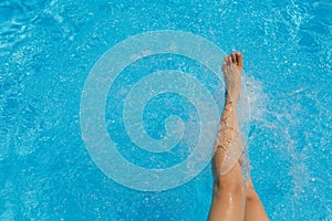 Nice pretty female feet, water splashes and turquoise pool water