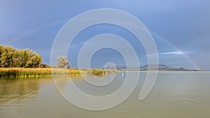 Nice rainbow over the lake Balaton of Hungary. Front of volcanoes near village Szigliget